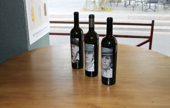 Trois bouteilles de vin rouge sur une table en bois
